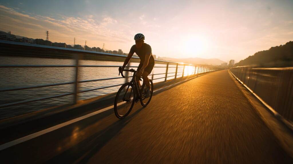 河川敷でクロスバイクに乗る40代日本人男性のトレーニング風景
