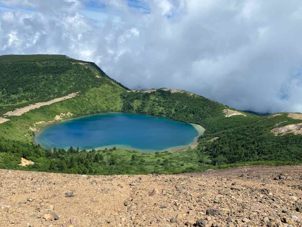 美しい火口湖に見惚れながら、水だけを持って補給ミスに陥る日本人男性ハイカー