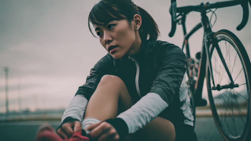 膝にやさしいクロストレーニングとして自転車に乗る日本人ランナー