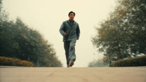 　- 公園でランニングを始めた40代男性がリラックスした表情で歩いている様子